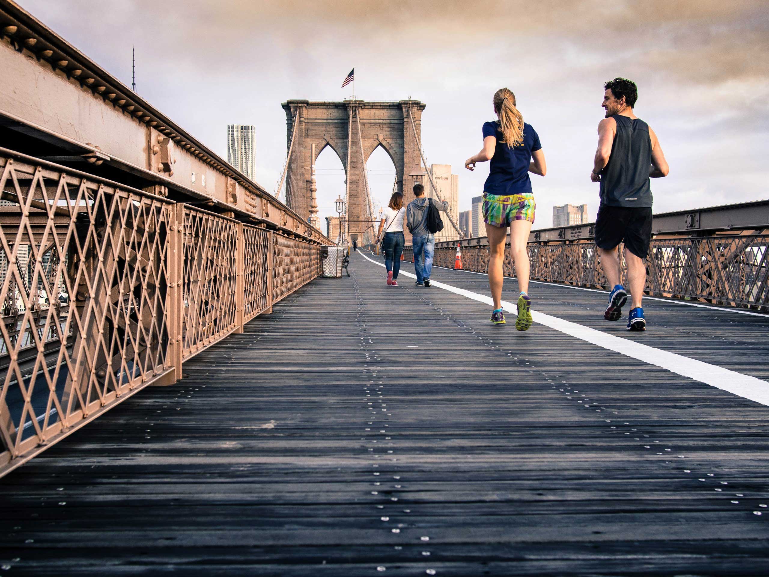 Two people running on a bridge