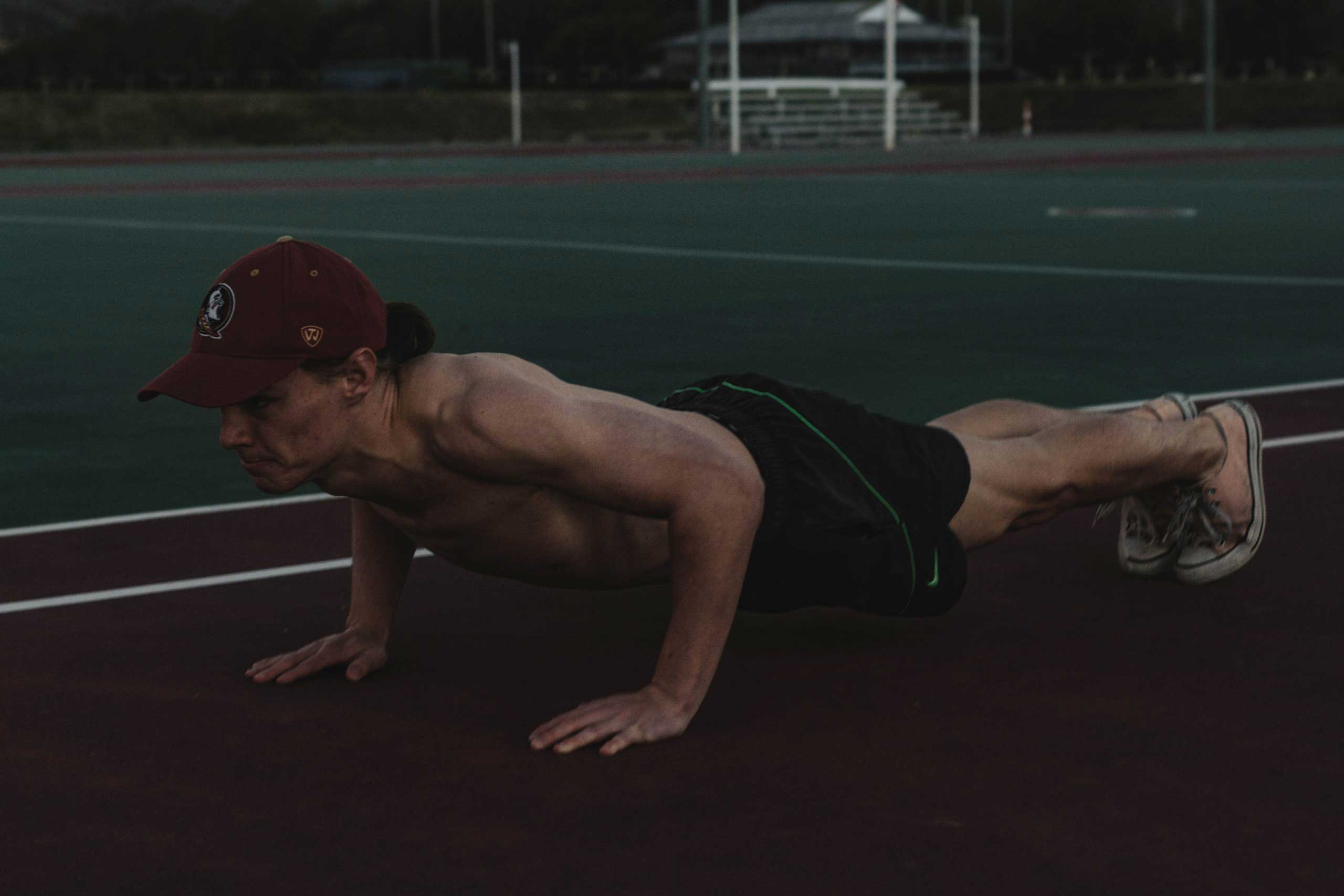 man doing pushups on running track