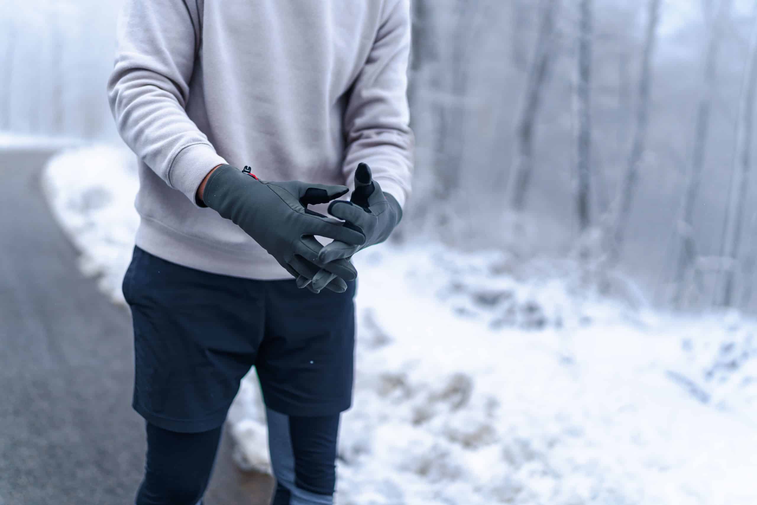a man wearing gloves running in the woods